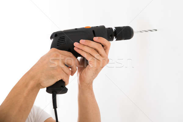 Man Using Power Drill On White Wall At Home Stock photo © AndreyPopov