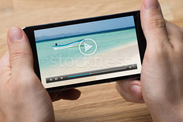 Man Playing Video On Smartphone At Desk Stock photo © AndreyPopov