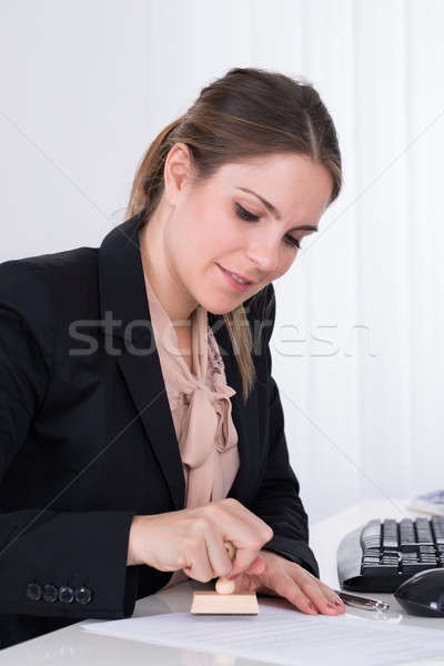 Businesswoman Pressing Wooden Stamp On Paper Stock photo © AndreyPopov