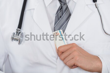 Doctor Hand Putting Money In Pocket Stock photo © AndreyPopov