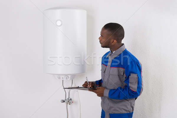 Plumber Looking At Electric Boiler Stock photo © AndreyPopov