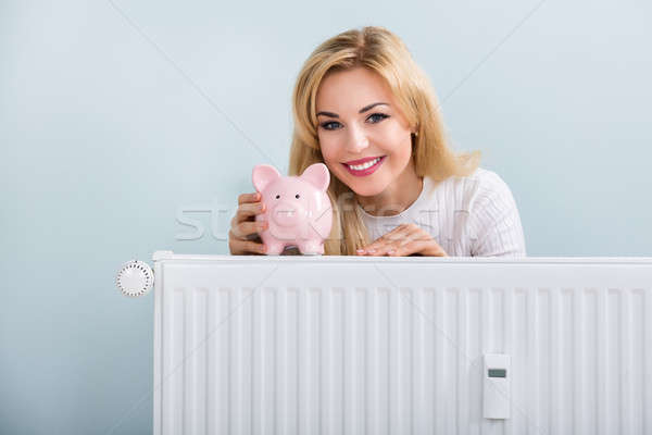 Szczęśliwy kobieta skarbonka radiator młodych domu Zdjęcia stock © AndreyPopov