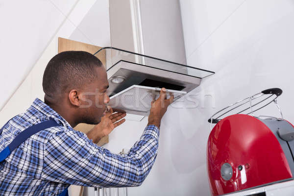 African Male Fixing Kitchen Extractor Filter Stock photo © AndreyPopov