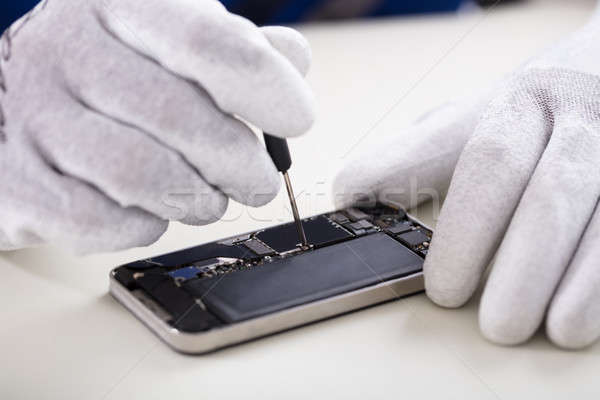 Emberi kéz javít okostelefon közelkép csavarhúzó telefon Stock fotó © AndreyPopov