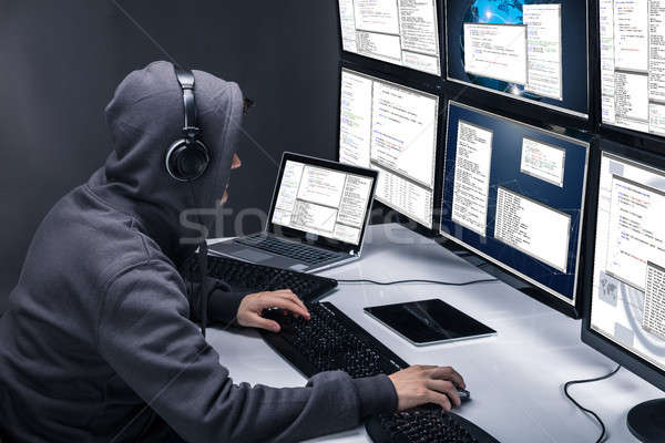 Stock photo: Hacker Using Multiple Computers For Stealing Data