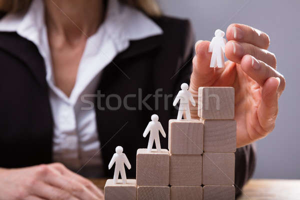 Businessperson Placing Human Figures On Staircase Stock photo © AndreyPopov