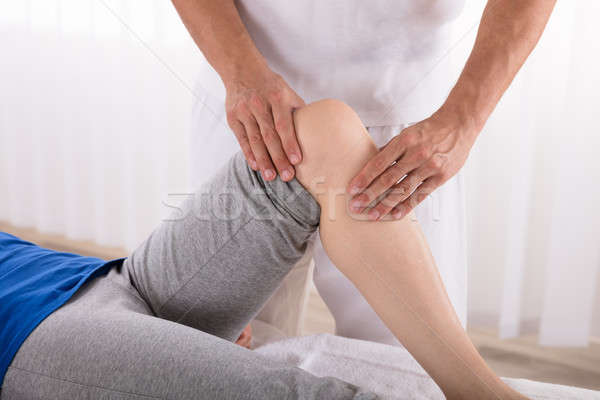 Physiotherapist Giving Knee Exercise To Woman Stock photo © AndreyPopov