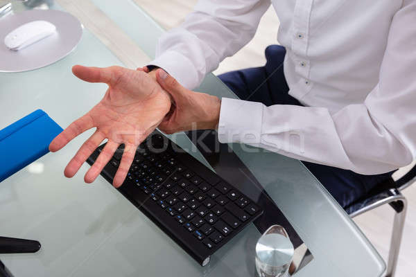 Geschäftsmann halten schmerzhaft Handwurzel Glas Schreibtisch Stock foto © AndreyPopov