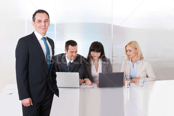 Stock photo: Man Standing In front Of Colleges Working In Office