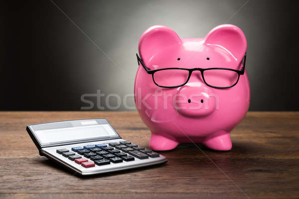 Skarbonka Kalkulator różowy drewniany stół drewna okulary Zdjęcia stock © AndreyPopov