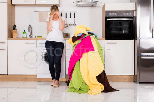 Exhausted Woman Standing Near Pile Of Clothes Stock photo © AndreyPopov
