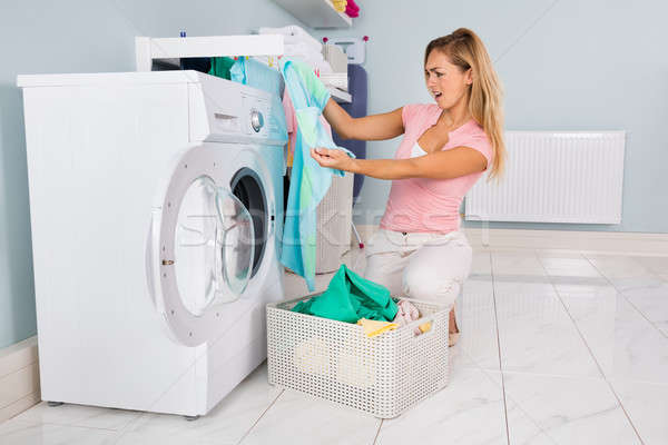 Woman Looking At Blue T-shirt After Laundering Stock photo © AndreyPopov