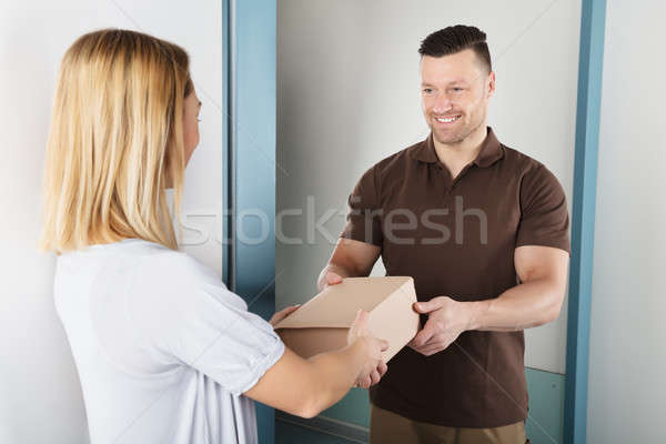 Delivery Man Giving Parcel Box To Young Woman Stock photo © AndreyPopov