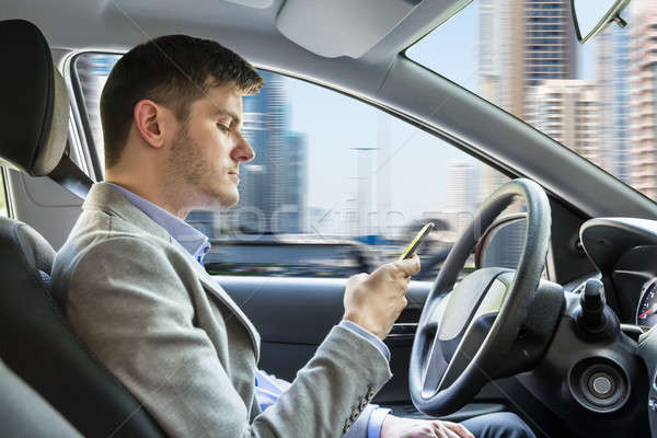 Man Sitting Inside Car Using Mobile Phone Stock photo © AndreyPopov