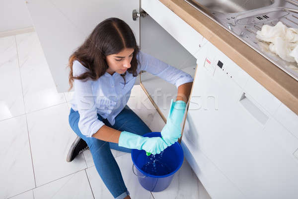 Woman Squeezing Water In Bucket Stock photo © AndreyPopov