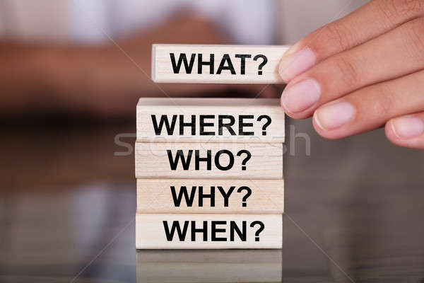 Stock photo: Hand Arranging A Set Of Questions On Wooden Block