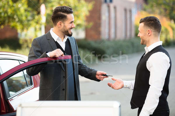 Young Businessman Giving Car Key To Valet Stock photo © AndreyPopov