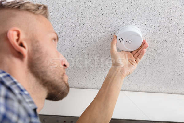 Person's Hand Installing Smoke Detector On Ceiling Stock photo © AndreyPopov