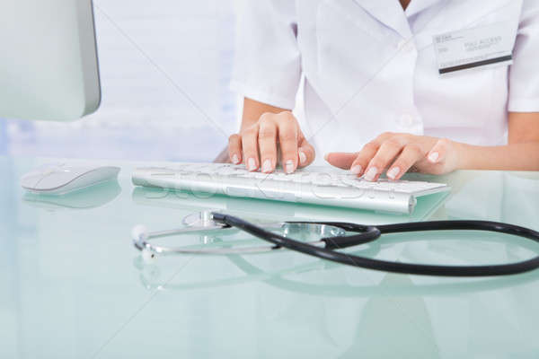 Stock photo: Doctor Typing On Computer Keyboard In Clinic