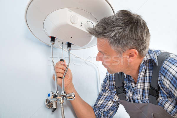 Stock photo: Plumber Repairing Water Heater