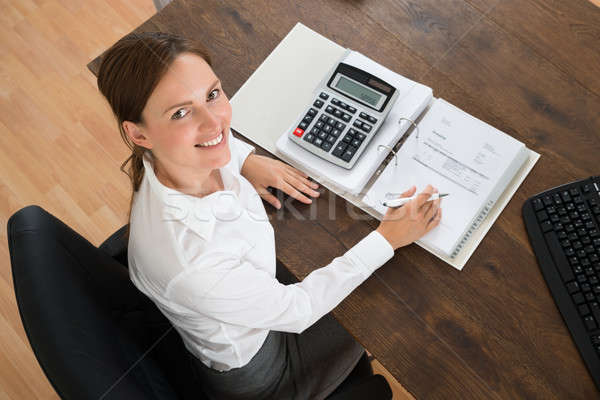 Femme d'affaires facture simulateur jeunes bois bureau [[stock_photo]] © AndreyPopov