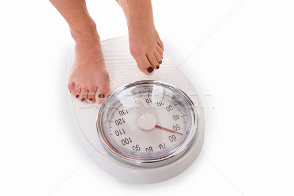 Low Section Of Woman Standing On Weighing Scale Stock photo © AndreyPopov