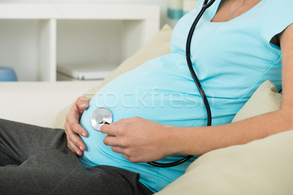 Pregnant Woman Holding Stethoscope On Stomach Stock photo © AndreyPopov