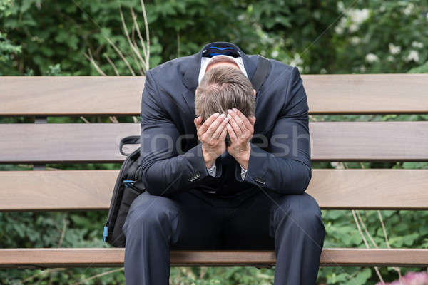 Triste empresario sesión banco jóvenes sufrimiento Foto stock © AndreyPopov