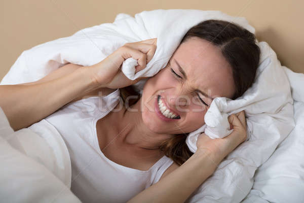 Woman Covering Ears To Shut Out Noise Stock photo © AndreyPopov