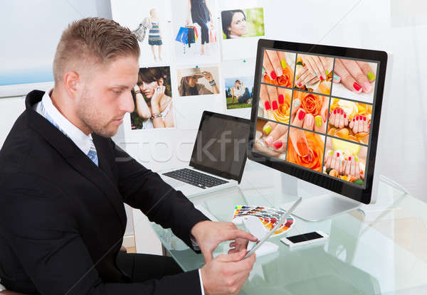 Businessman editing photographs Stock photo © AndreyPopov