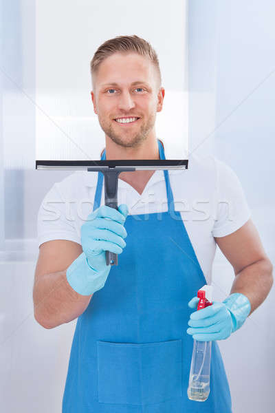Male janitor using a squeegee to clean a window Stock photo © AndreyPopov