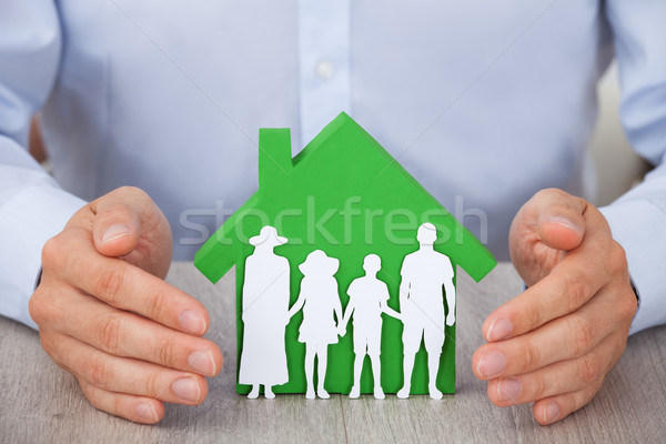 Hands Protecting Green Model House And Family Stock photo © AndreyPopov
