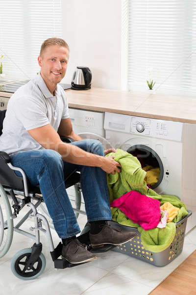 Homem cadeira de rodas roupa máquina de lavar roupa jovem feliz Foto stock © AndreyPopov