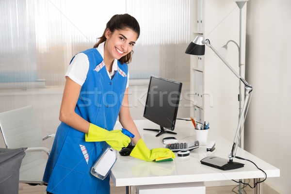 Worker Cleaning Computer Desk With Spray And Sponge Stock photo © AndreyPopov
