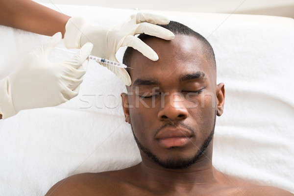 Person Hand Injecting Syringe On Young Man Face Stock photo © AndreyPopov