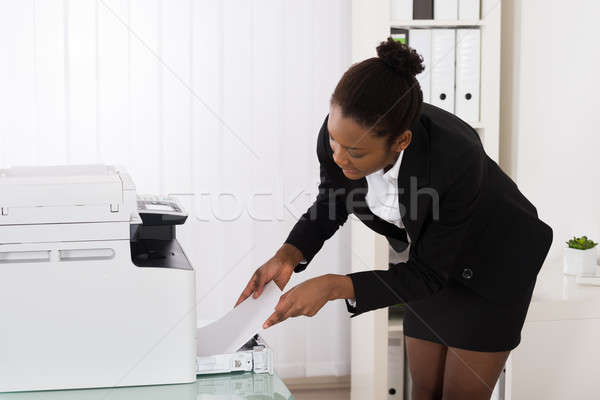 Businesswoman Inserting Papers In Photocopy Machine Stock photo © AndreyPopov