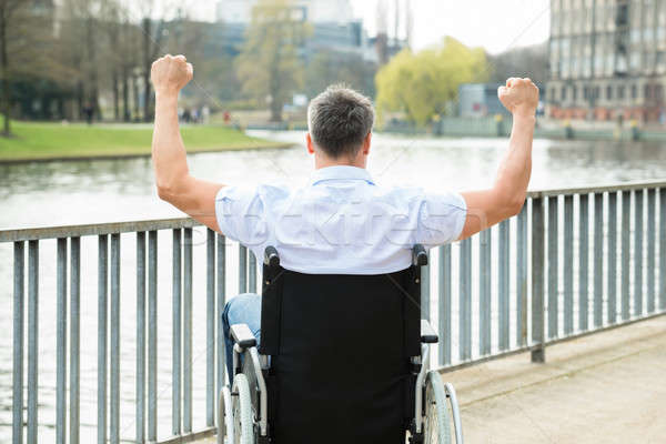 Disabled Man On Wheelchair With Hand Raised Stock photo © AndreyPopov