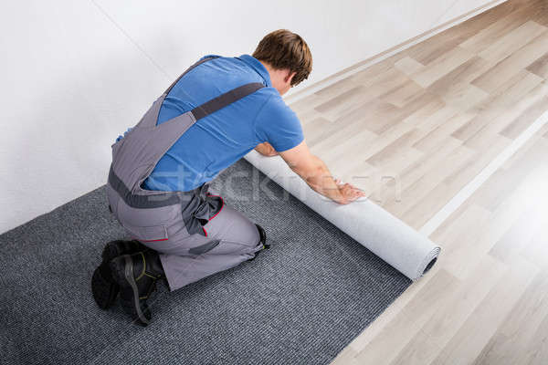 Handyman Rolling Carpet On Floor Stock photo © AndreyPopov