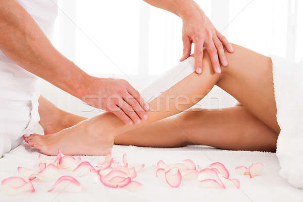 Beautician waxing a woman leg Stock photo © AndreyPopov