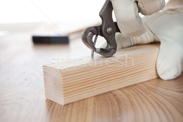 Worker pulling a nail from a plank Stock photo © AndreyPopov