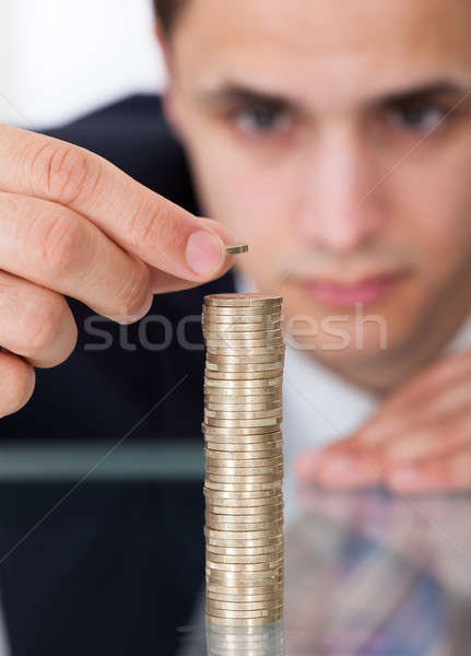 Businessman Stacking Coins At Desk Stock photo © AndreyPopov