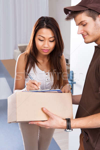 Woman Signing While Receiving Courier Stock photo © AndreyPopov