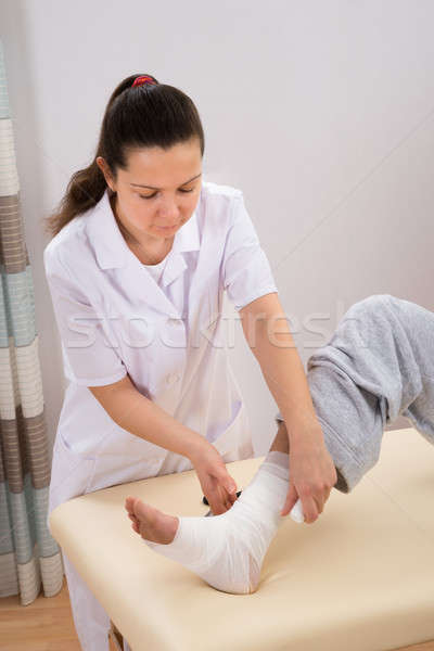 Asistentă bandaj picior tineri clinică mână Imagine de stoc © AndreyPopov