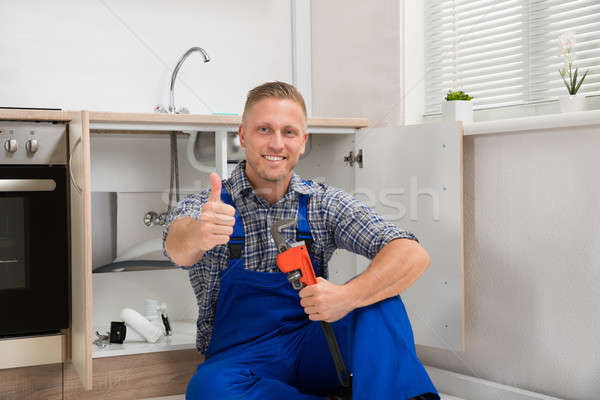 Plumber With Adjustable Wrench In Kitchen Room Stock photo © AndreyPopov