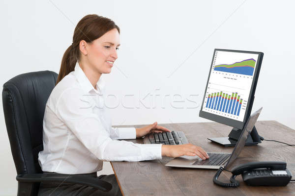 Businesswoman Working On Statistical Reports On Computer Stock photo © AndreyPopov