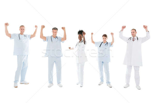 Stock photo: Multiethnic Medical Team Standing With Arms Raised