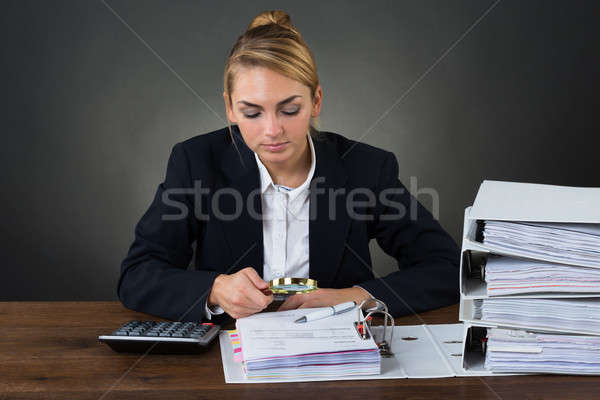 Businesswoman Examining Bills With Magnifying Glass Stock photo © AndreyPopov