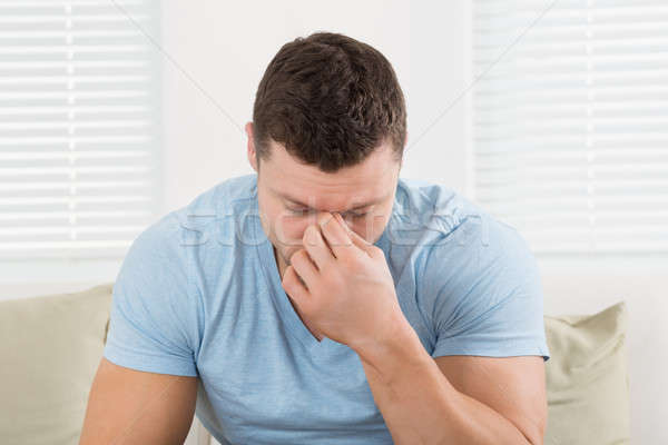 Man With Headache Pinching His Nose At Home Stock photo © AndreyPopov