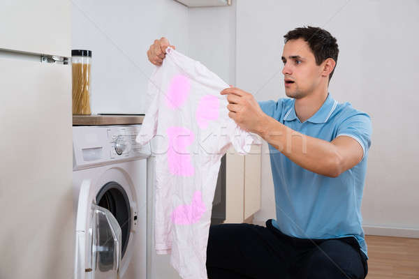 Shocked Man Looking Dirty Tshirt By Washing Machine Stock photo © AndreyPopov