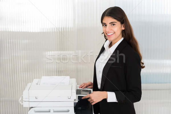 Businesswoman Using Photocopy Machine In Office Stock photo © AndreyPopov